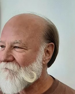 A neatly shaped and styled long silver beard